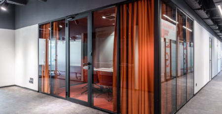 Modern office remodeling with glass partitions, meeting rooms, and contemporary commercial interior design in Michigan