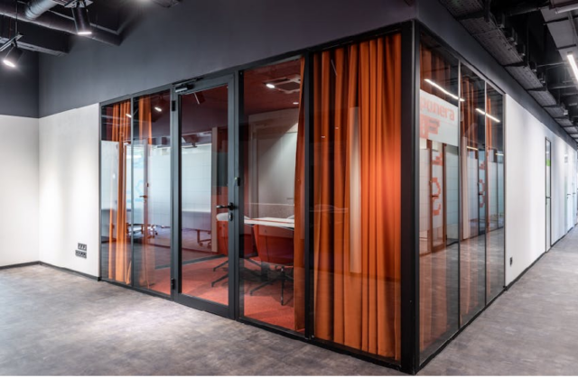 Modern office remodeling with glass partitions, meeting rooms, and contemporary commercial interior design in Michigan